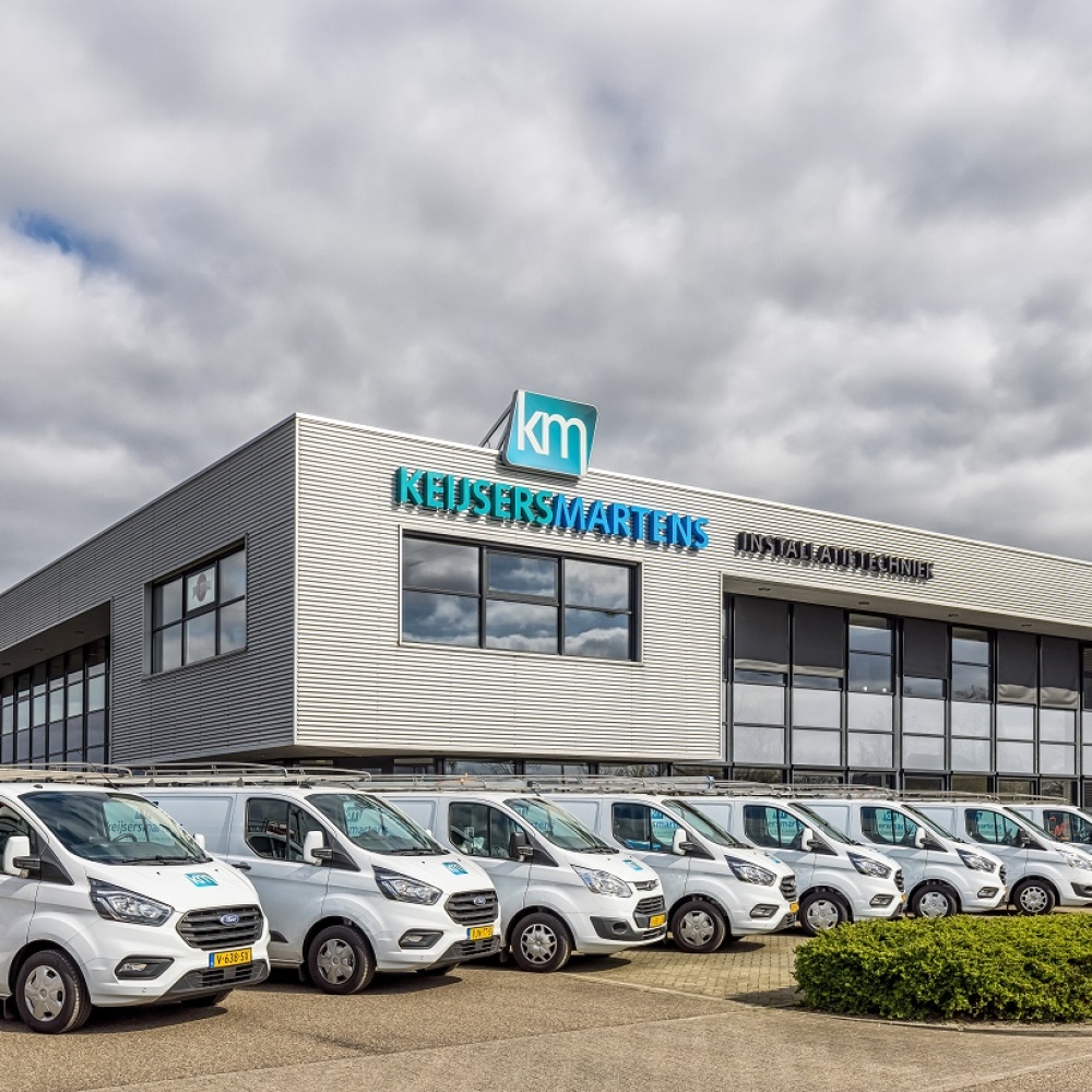 Bedrijfspand van Keijsers Martens met een rij bedrijfsbussen ervoor