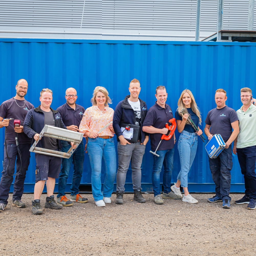Team van Keijsers Martens met gereedschap voor een blauwe container
