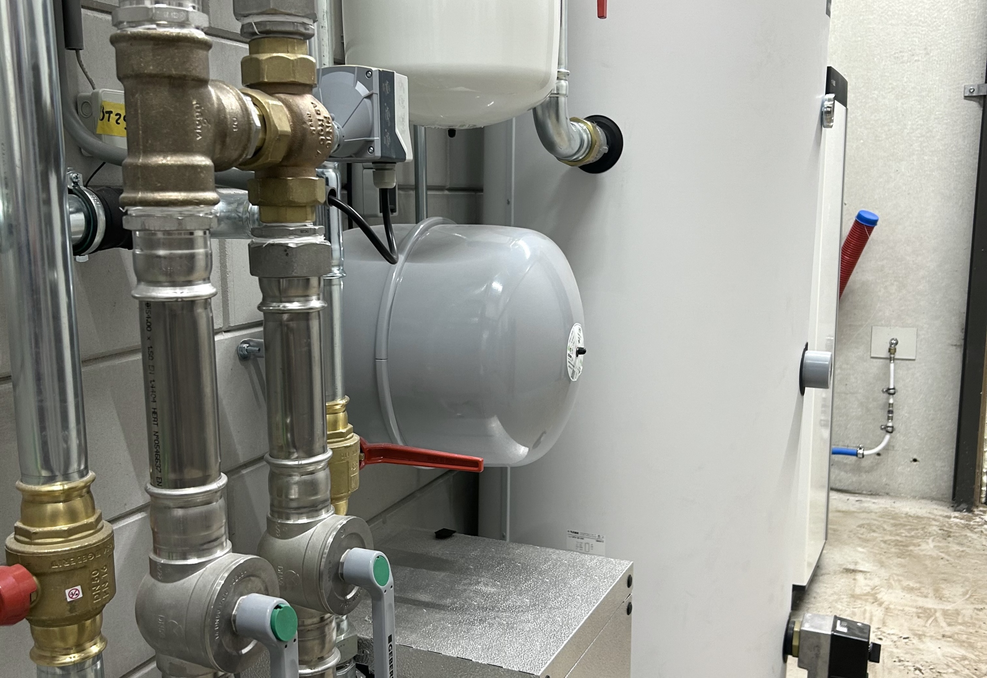 Warmtepompinstallatie met leidingwerk en expansievaten in een technische ruimte