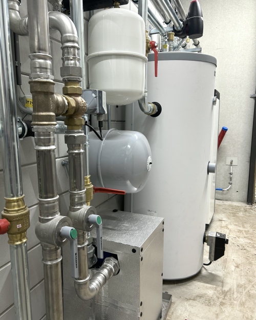 Warmtepompinstallatie met leidingwerk en expansievaten in een technische ruimte