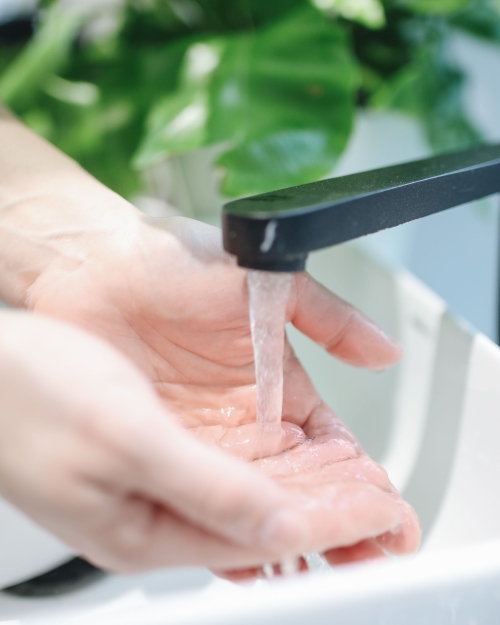Handen onder stromend water uit een kraan